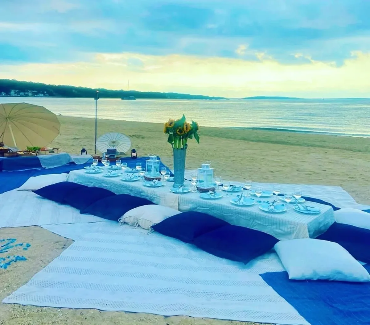 Beach picnic table with blue cushions and ocean views